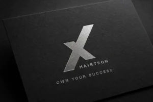 Logotipo de Nexha Hairtech en relieve plateado sobre papel de algodón, diseñado por Creatias Estudio