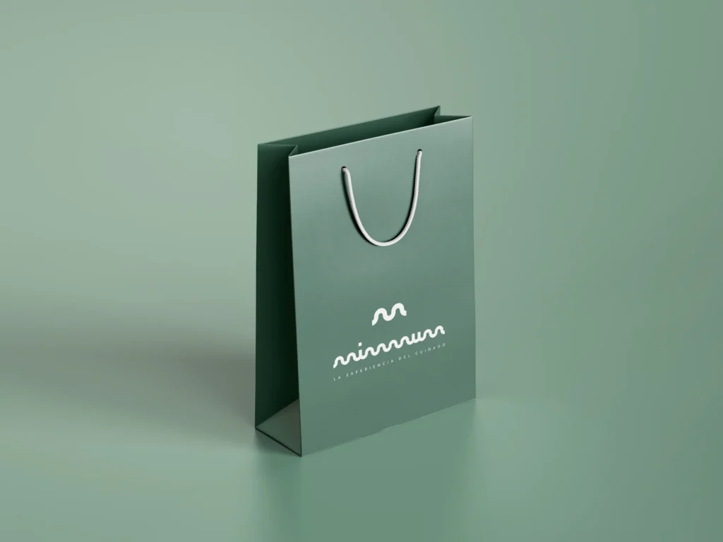 Bolsa de papel verde de MIMMUM con el logotipo y el claim, diseñado por Creatias Estudio