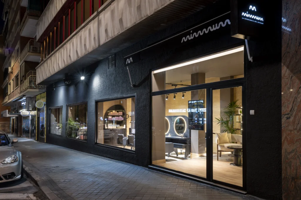 Fachada de MIMMUM con rótulo luminoso y banderola con el símbolo, diseñado por Creatias Estudio