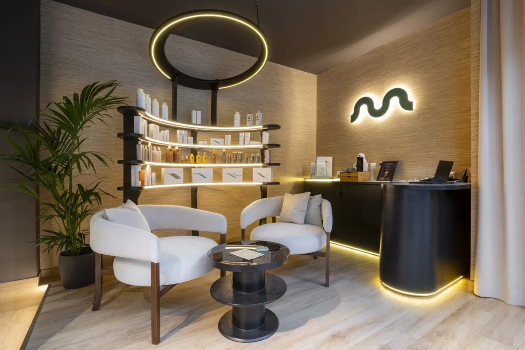 Recepción de MIMMUM con el símbolo retroiluminado, interiorismo de Carlos Roma, diseñado por Creatias Estudio